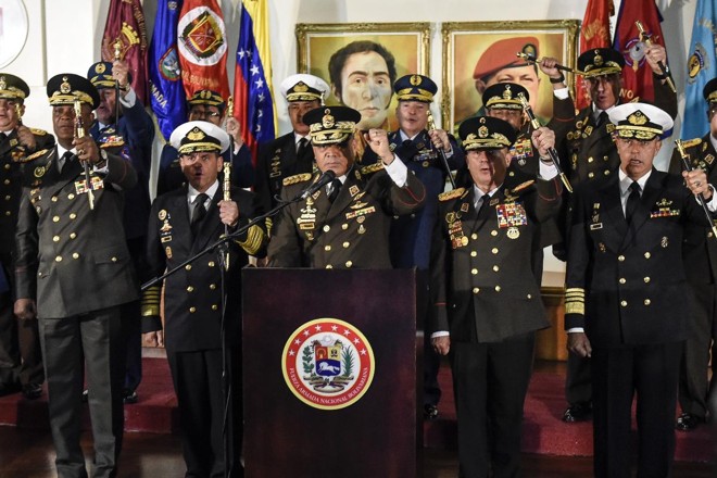 O ministro da Defesa da Venezuela, Vladimir Padrino López, cercado de oficiais militares de alto escalão, em pronunciamento transmitido na quinta (24), em que declaram lealdade a Maduro | Carlos Becerra / Bloomberg