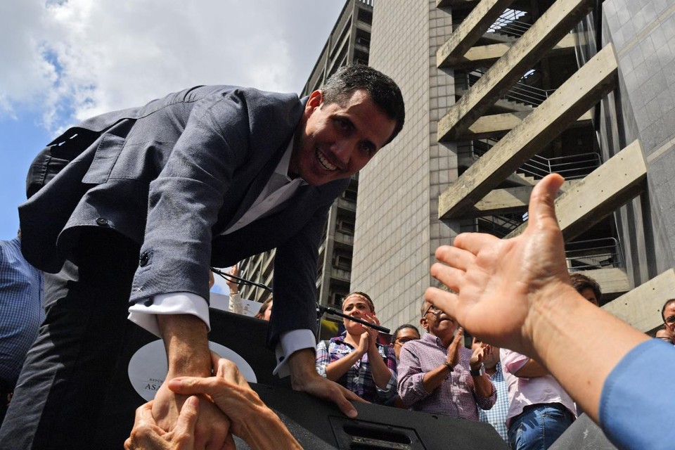 O presidente da Assembleia Nacional da Venezuela, Juan Guaidó, cumprimenta apoiadores durante encontro aberto em Caracas nesta sexta-feira (11) | YURI CORTEZ / AFP