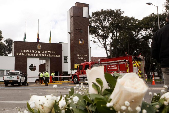 Flores deixadas em homenagem às vítimas do ataque a bomba que matou 21 pessoas e feriu 68 na frente da Academia de Cadetes General Santander, em Bogotá, capital da Colômbia | DANIEL MUNOZ / AFP