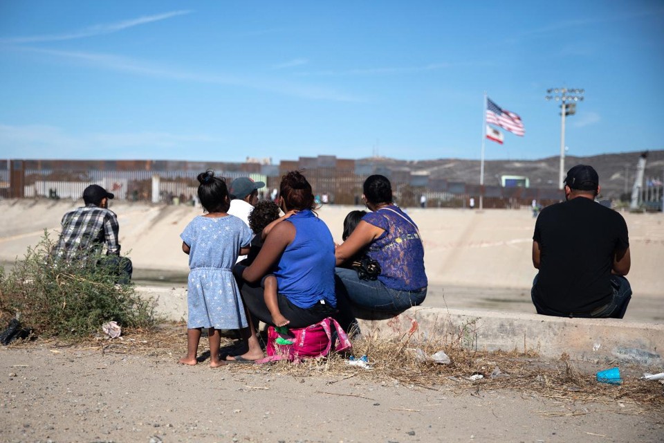 Migrantes da América Central sentam na borda do Rio Tijuana, perto da fronteira com os Estados Unidos em Tijuana, México, em 25 de novembro de 2018 |  Tomas Ayuso / Bloomberg