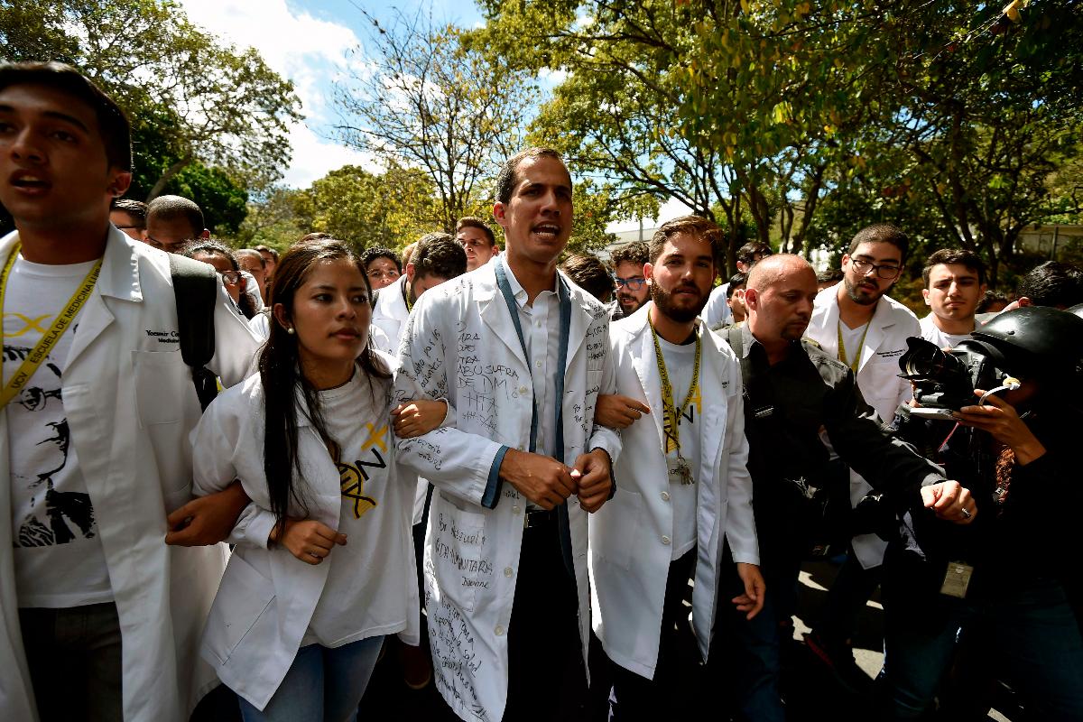 O líder da oposição, Juan Guaido (C), marcha com estudantes durante um protesto que convocou contra o governo do ditador Nicolas Maduro, em frente à Universidade Central da Venezuela (UCV) em Caracas | LUIS ROBAYO/AFP
