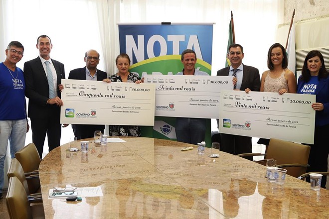 Contemplados no 38º sorteio do Nota Paraná posam com os cheques simbólicos das premiações. | Divulgação/AENPr