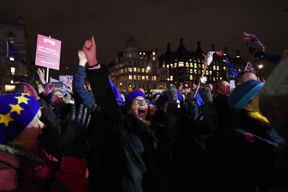Pessoas reagem ao resultado da votação sobre o acordo do Brexit no Parlamento britânico | OLI SCARFF / AFP