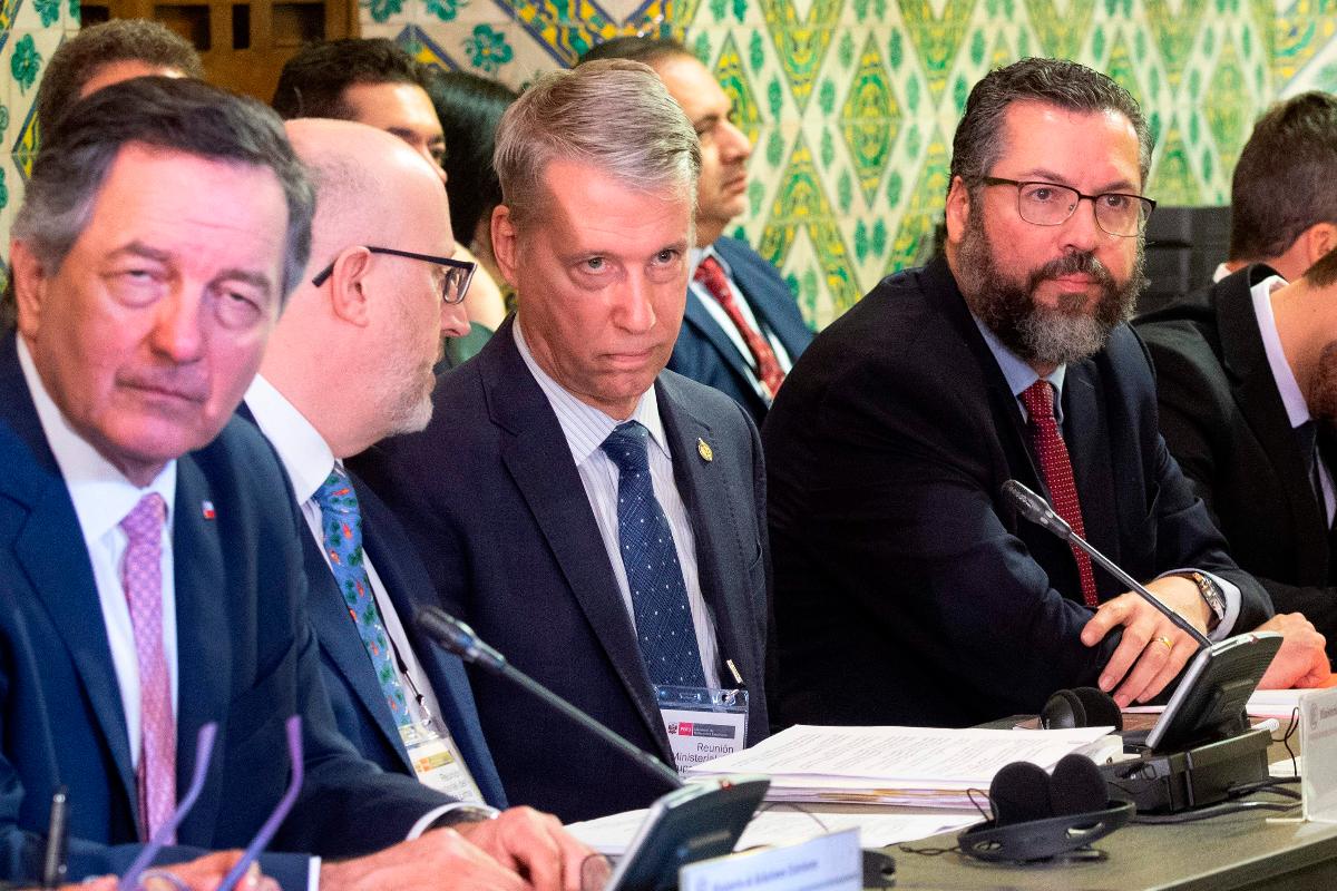 O ministro das Relações Exteriores do Chile, Roberto Ampuero; o secretário parlamentar para o ministro das Relações Exteriores do Canadá, Andrew Leslie; e o Ministro das Relações Exteriores do Brasil, Ernesto Araújo participam da reunião do Grupo de Lima, 4 de janeiro | CRIS BOURONCLE / AFP