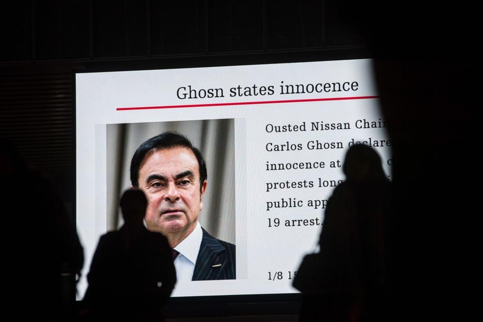 Pedestres acompanharam a audiência de Carlos Ghosn, ex-executivo da Nissa,  em telões em Tóquio, Japão. | BEHROUZ MEHRI/AFP