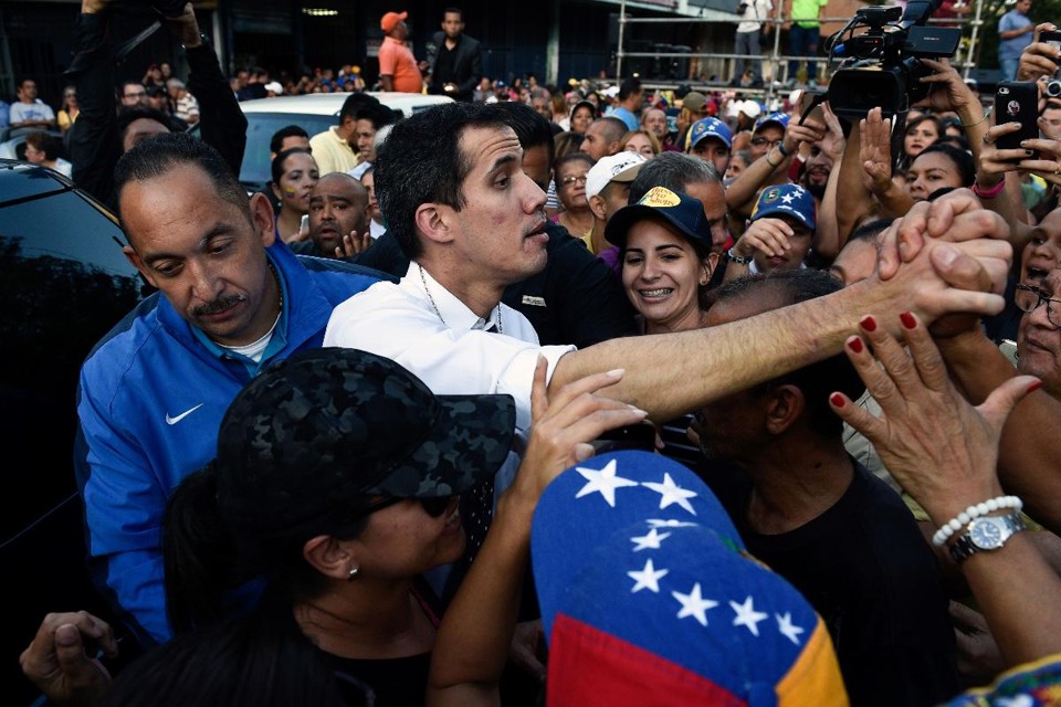 O presidente da Assembléia Nacional da Venezuela, Juan Guaidó, cumprimenta partidários durante uma assembleia aberta no bairro de Caricuao, no sudoeste de Caracas, em 19 de janeiro de 2019 | FEDERICO PARRA/AFP