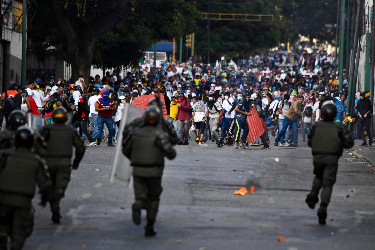 A polícia de choque enfrenta manifestantes durante protesto contra o regime do ditador Nicolás Maduro, 23 de janeiro, em Caracas | YURI CORTEZ / AFP