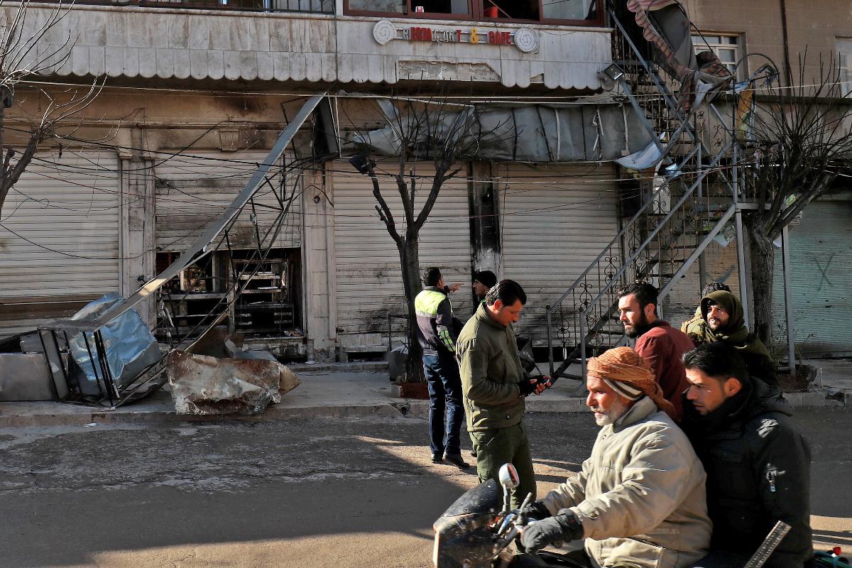 Sírios checam o local de um atentado suicida contra as forças de coalizão lideradas pelos EUA na cidade de Manbij, no norte da Síria, que matou quatro militares em 16 de janeiro de 2019 | DELIL SOULEIMAN/AFP