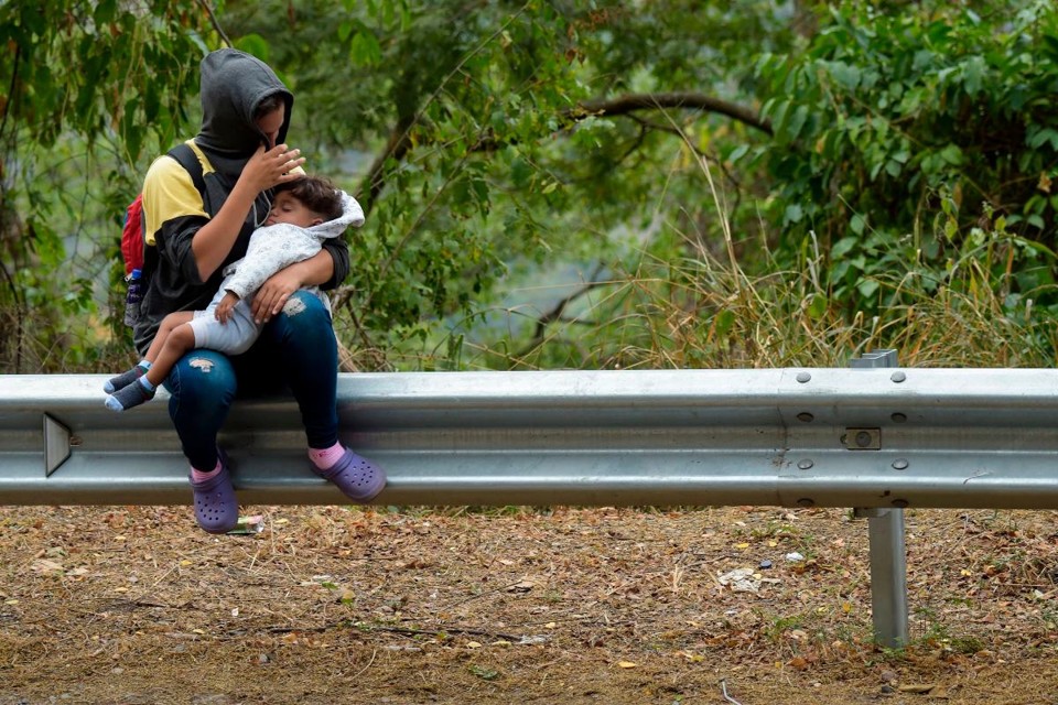 Enquanto segue o impasse sobre a entrada de ajuda humanitária, milhares de venezuelanos deixam diariamente o país. Na foto, uma mulher e uma criança descansam no caminho entre Cúcuta e Pamplona, na Colômbia, em 10 de fevereiro de 2019 | RAUL ARBOLEDA/AFP