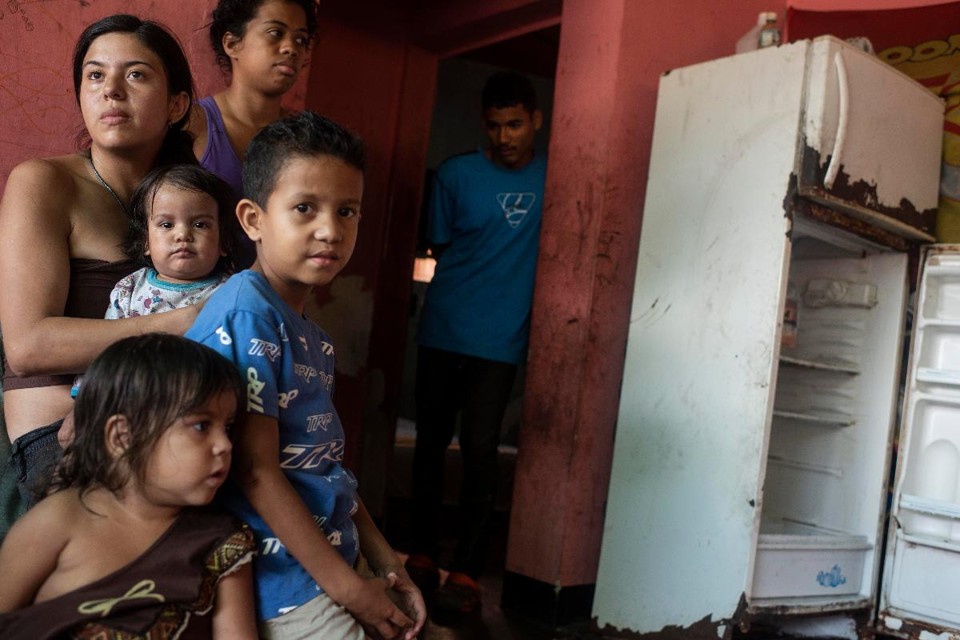 Viviana Colmenares, 26, à esquerda, Andres Colima, 20 anos, à direita, e sua família em sua casa em uma favela de Caracas, na Venezuela | Michael Robinson Chavez/The Washington Post