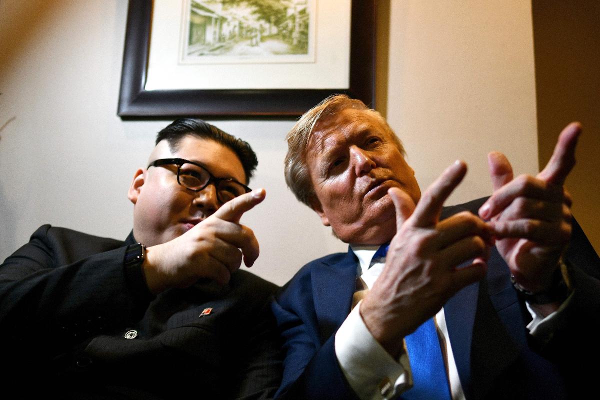 Sósias de Kim Jong-un, Howard X, e do presidente Donald Trump, Russel White, posam para fotos no Metropole Hotel em Hanói, em 22 de fevereiro de 2019 | MANAN VATSYAYANA/
AFP
