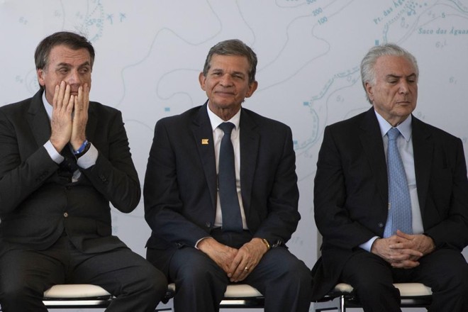 General Joaquim Silva e Luna, novo diretor da Itaipu, sentado entre Jair Bolsonaro e Michel Temer. | MAURO PIMENTEL/AFP