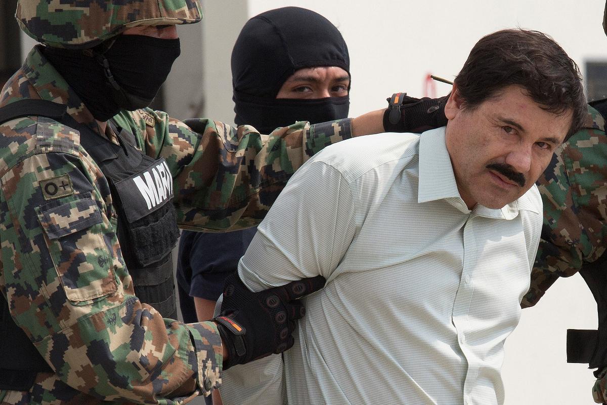 Joaquin "El Chapo" Guzman é levado a um helicóptero pelas forças de segurança mexicanas, no Aeroporto Internacional do México, no México, em 22 de fevereiro de 2014 | Susana Gonzalez/Bloomberg