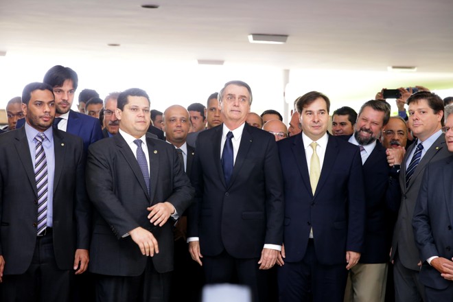 Bolsonaro ao lado dos presidentes do Senado, Davi Alcolumbre (esq.), da Câmara, Rodrigo Maia, e de outros parlamentares: medida para formar a base aliada. | Cleia Viana