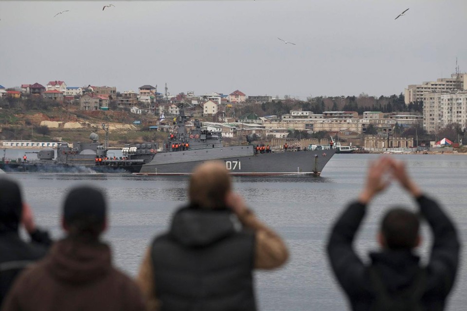 Cinco anos de ocupação russa na Crimeia: verdades e mitos Pessoas observam um navio russo entrando na cidade portuária de Sebastopol, na Crimeia, em 2 de março de 2014 | BR/KV / BAZ RATNER