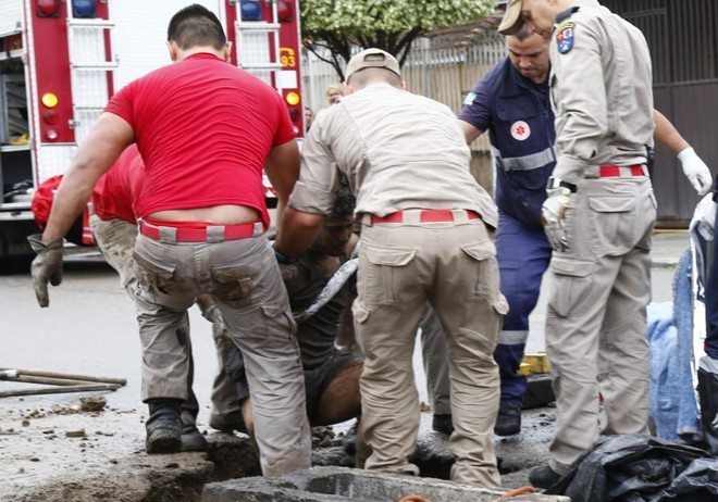 Bombeiros retiram o homem que ficou preso no bueiro no bairro Cajuru na manhã desta quinta-feira. | Aniele Nascimento / Gazeta do Povo