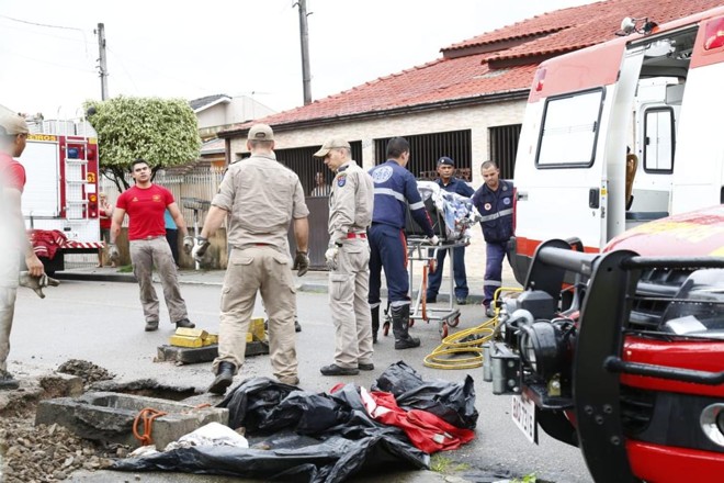 Bombeiros retiram o homem que ficou preso no bueiro no bairro Cajuru na manhã desta quinta-feira. | Aniele Nascimento / Gazeta do Povo