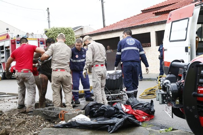 Bombeiros retiram o homem que ficou preso no bueiro no bairro Cajuru na manhã desta quinta-feira. | Aniele Nascimento / Gazeta do Povo