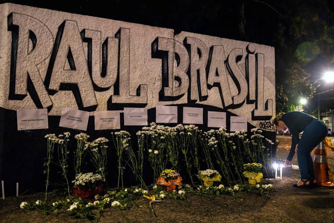 Flores são depositadas em frente ao Colégio Raul Brasil: homenagem às vítimas. | Nelson Almeida/AFP
