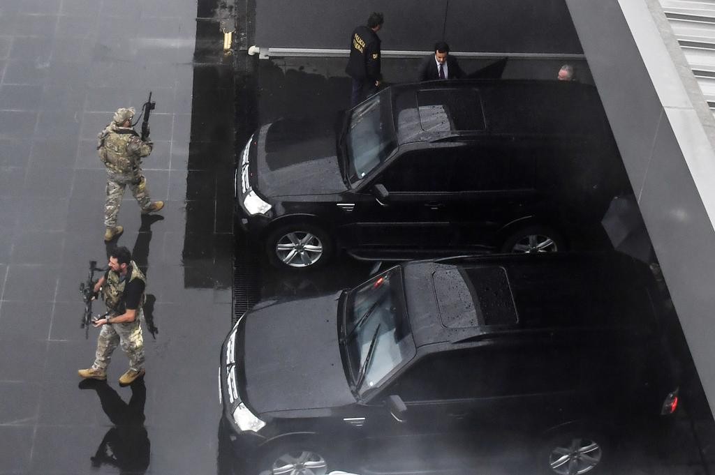 Michel Temer (no alto, à direita), entra no carro da Polícia Federal em que seria conduzido ao avião que o levou ao Rio de Janeiro.
