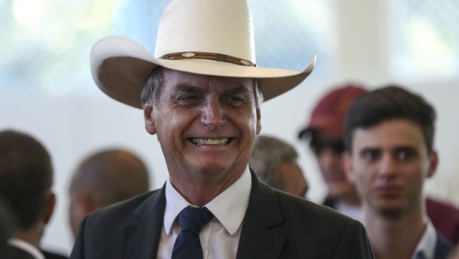 Jair Bolsonaro usando chapéu em encontro com cantores sertanejos em Brasília em dezembro de 2018.