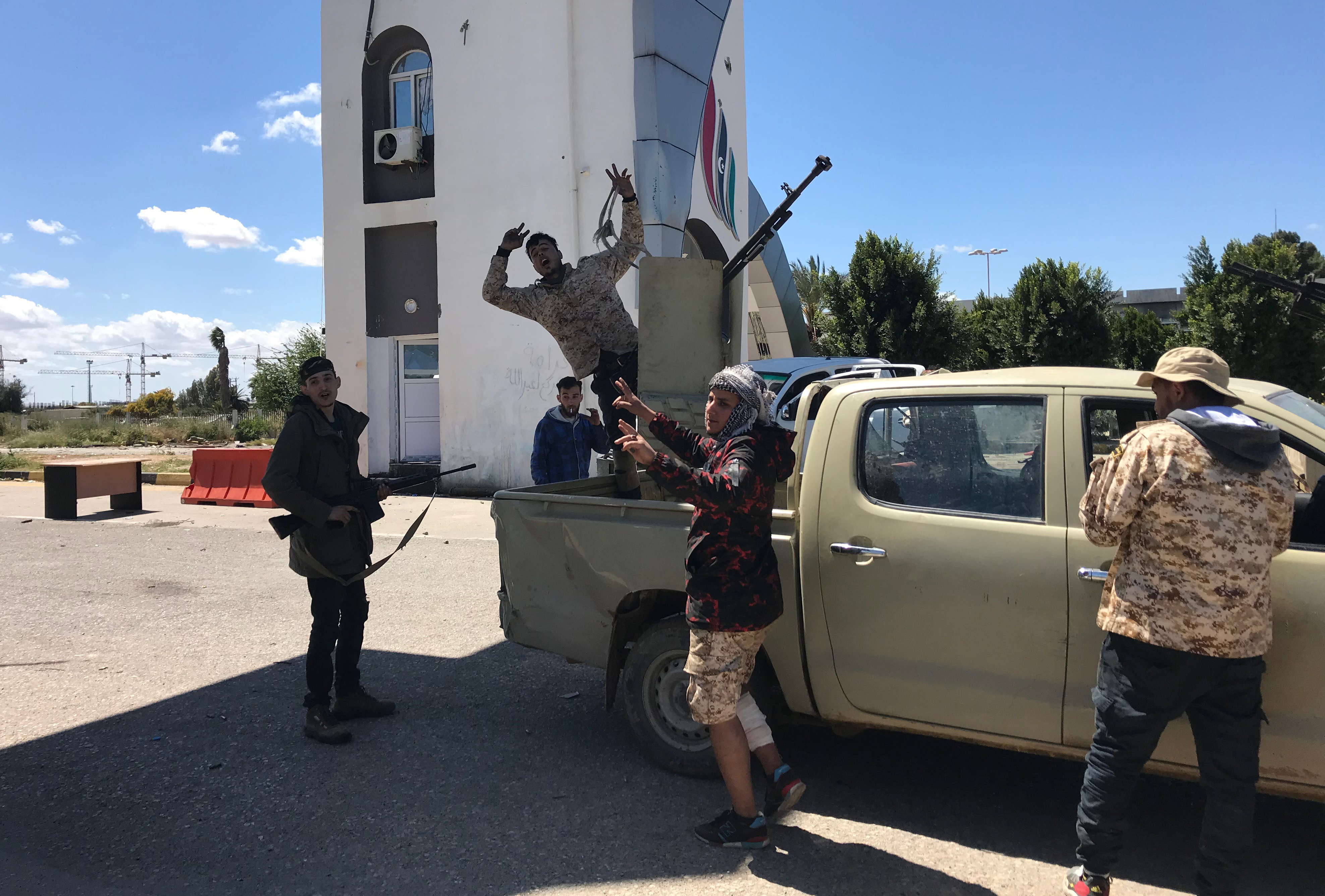 Forças leais ao internacionalmente reconhecido Governo da Líbia do Acordo Nacional (GNA) são retratadas no portão de entrada do antigo aeroporto de Trípoli em 8 de abril de 2019 | Foto: Mahmud TURKIA/AFP
