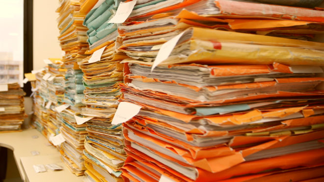 Pilha de processos parados em fórum. Burocracia. Papelada.