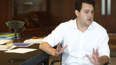 Ratinho Junior ao lado de sua mesa de trabalho no Palácio Iguaçu.