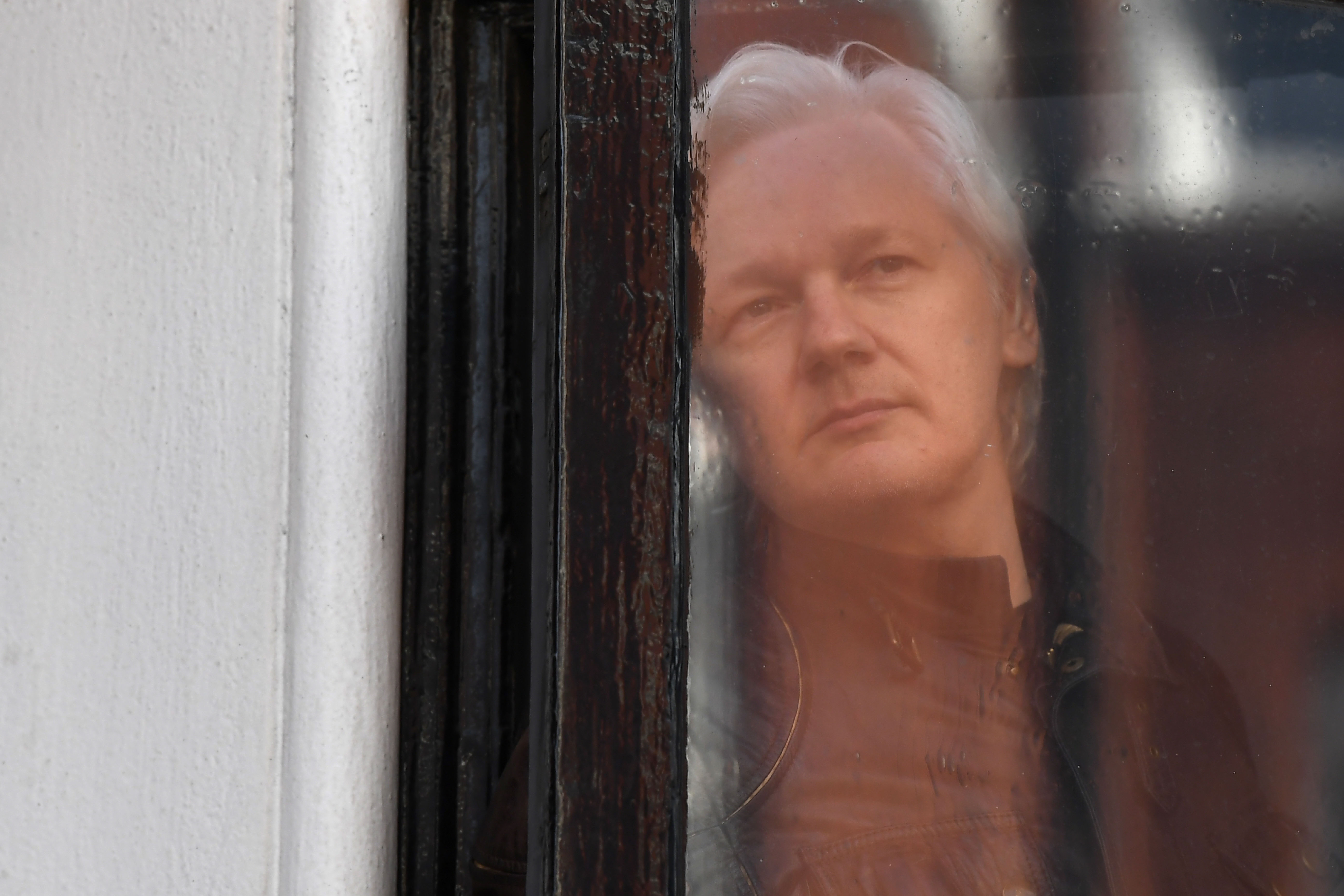 Julian Assange, na Embaixada do Equador em Londres | Foto: Justin TALLIS/AFP