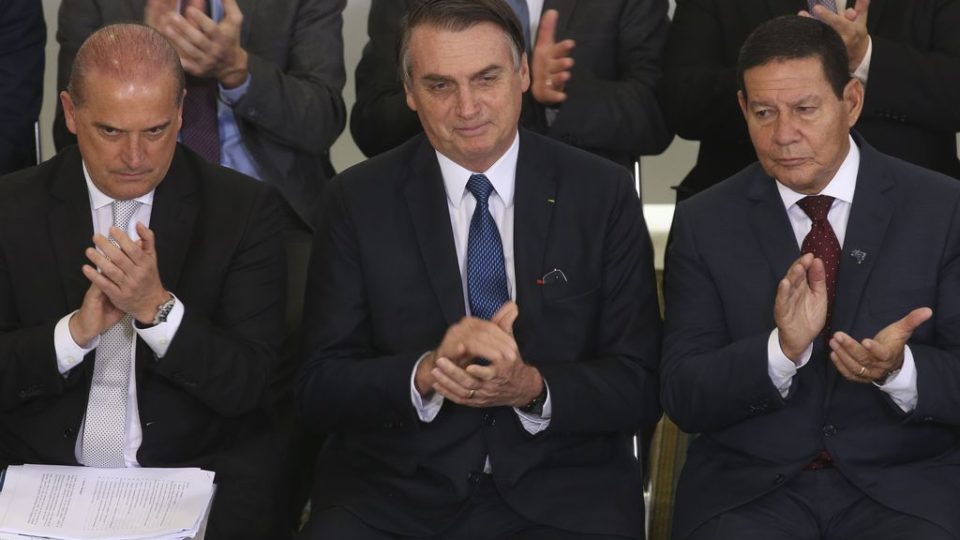 O presidente Jair Bolsonaro ladeado pelo vice-presidente Hamilton Mourão (à dir.) e o ministro Onyx (à esq.) na cerimônia sobre os 100 dias de governo. Foto: Antônio Cruz/Agência Brasil