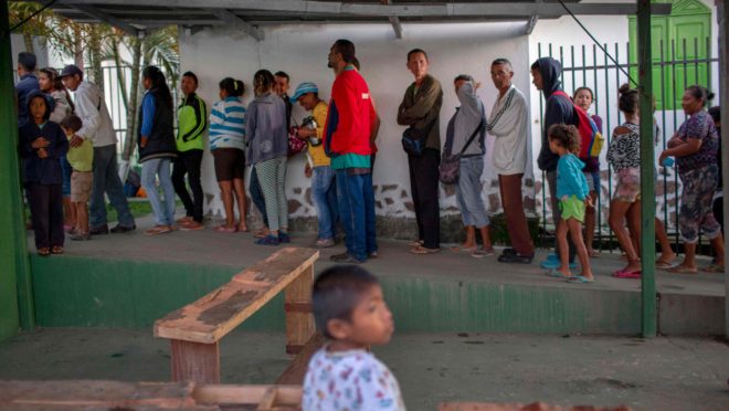 Fila de venezuelanos para pegar o café da manhã em Pacaraima, Roraima.