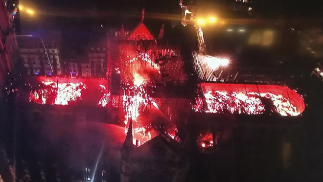 Imagem transmitida pela televisão mostra vista aérea da catedral de Notre-Dame durante o incêndio desta segunda-feira (15)