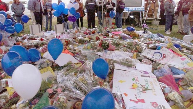 Foto de 21 de abril de 1999 mostra moradores de Littleton, no estado americano do Colorado, próximos a flores deixadas em homenagem às vítimas do massacre de Columbine, em que dois atiradores mataram e feriram colegas da escola em 20 de abril de 1999. Foto: Hector Mata / AFP