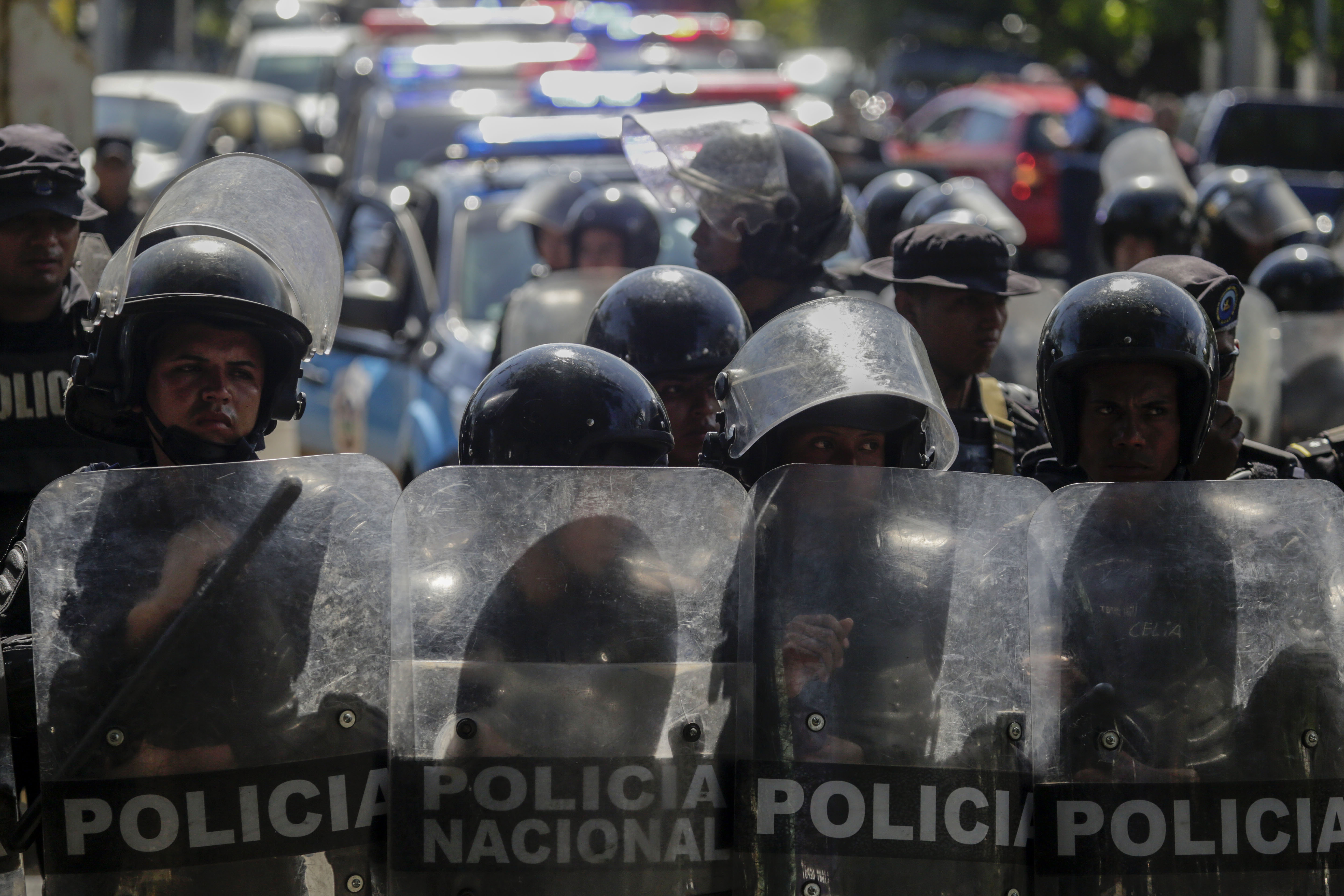 Polícia de choque ao lado de um estacionamento onde manifestantes da oposição protestam contra o governo, em 17 de abril de 2019 | Foto: INTI OCON / AFP