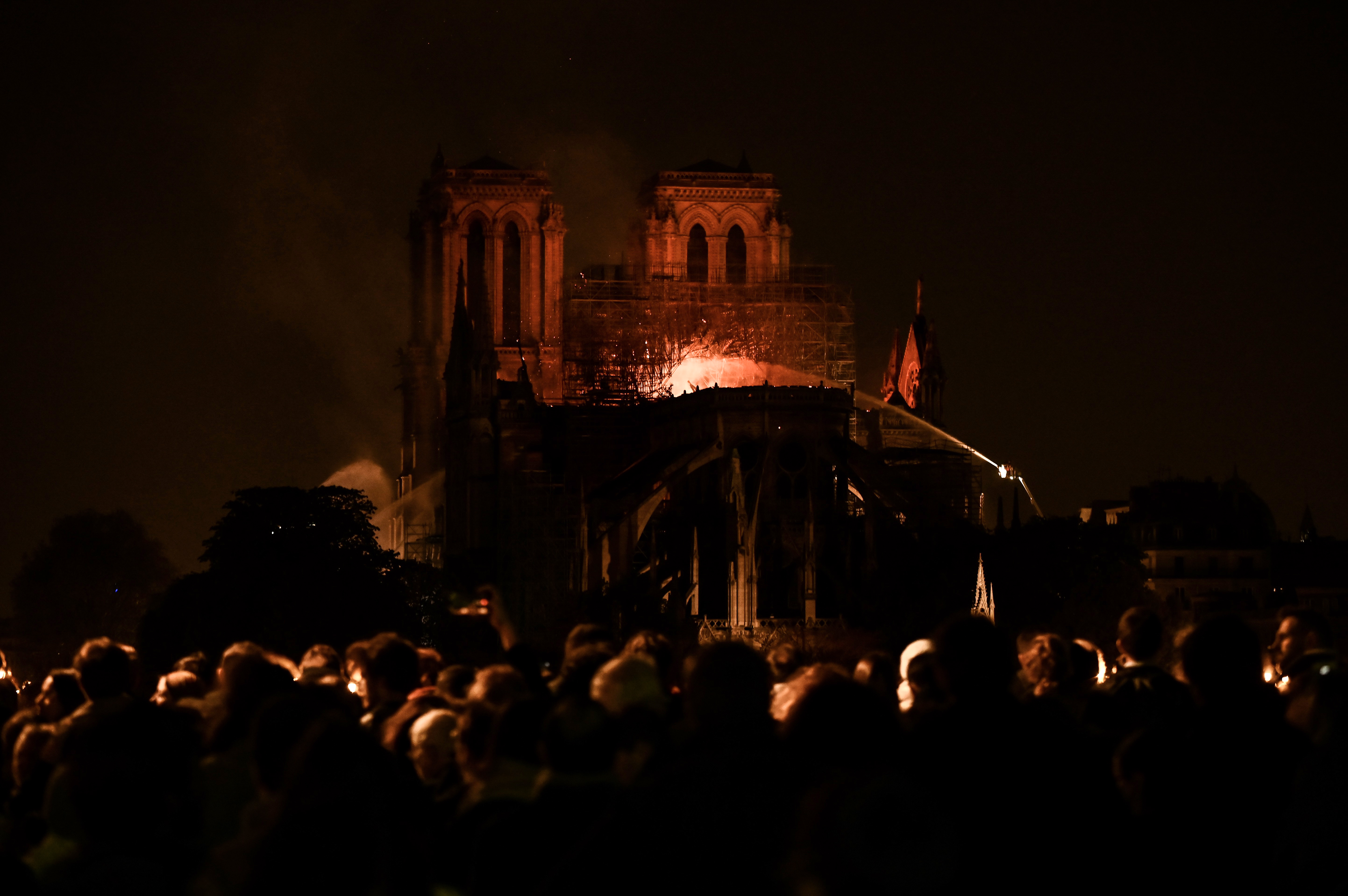 Multidão acompanha a catedral de Notre-Dame em chamas.