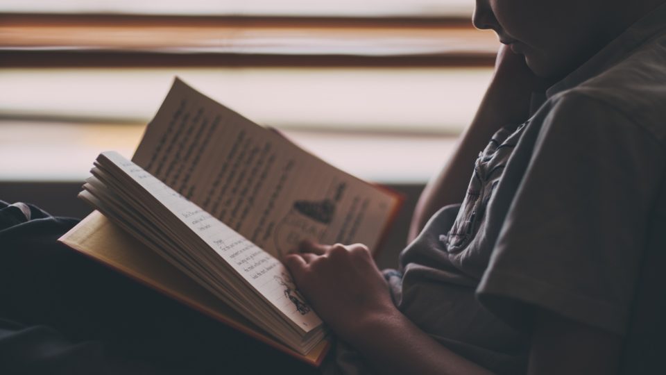 Criança lendo um livro.
