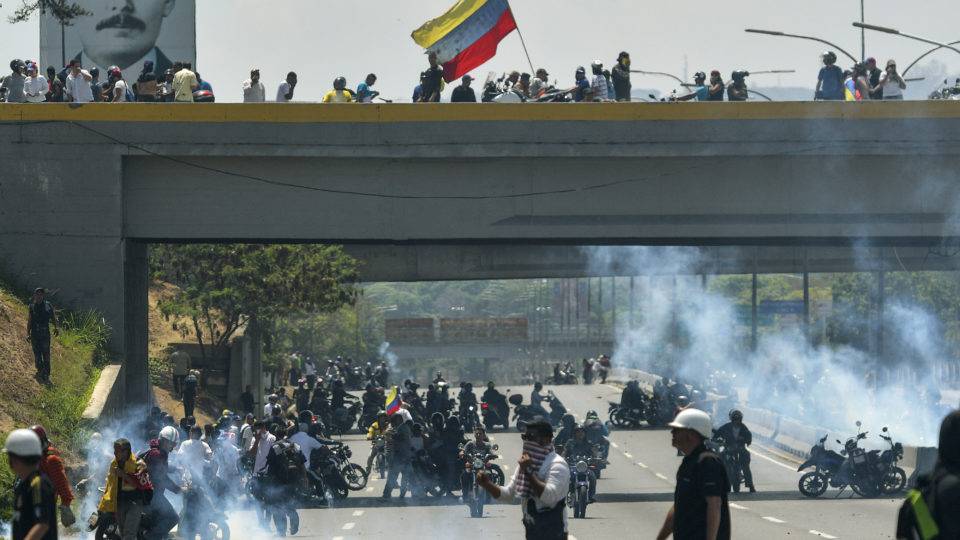Manifestantes pró-Guaidó entram em conflito com militares leais ao ditador Nicolás Maduro | Foto: Matias DELACROIX / AFP