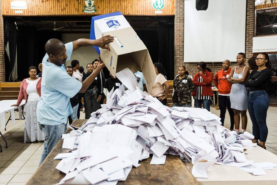 Um Oficial Eleitoral Independente abre uma urna durante o início da contagem de votos em uma escola após o término da votação na cidade de Durban, África do Sul, 8 de maio