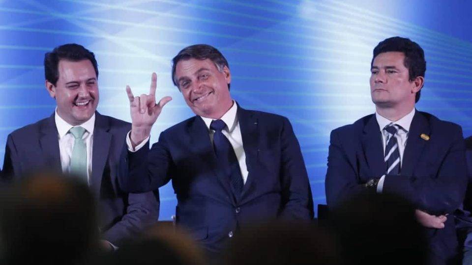 Jair Bolsonaro, entre Ratinho Jr e Sergio Moro, durante solenidade no Paraná.