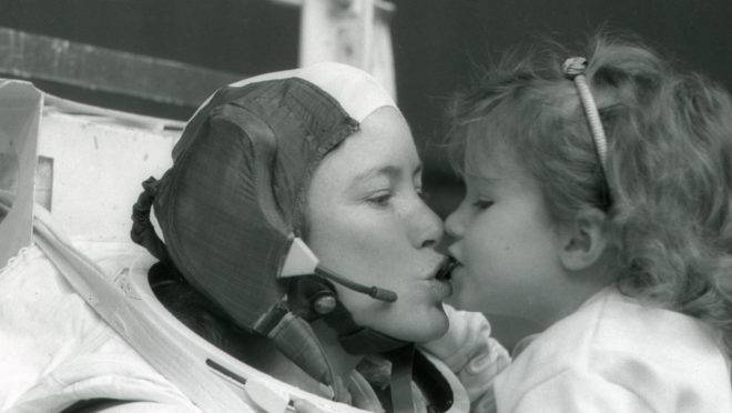 A astronauta Anna Fisher beija sua filha Kristin depois de treinar em Houston para uma caminhada espacial, em 1985.