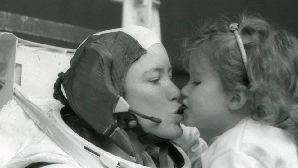 A astronauta Anna Fisher beija sua filha Kristin depois de treinar em Houston para uma caminhada espacial, em 1985.