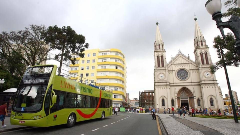 Cinema e turismo: programas para aproveitar Curitiba gastando até R$ 10 ônibus da linha turismo em frente à Catedral de Curitiba