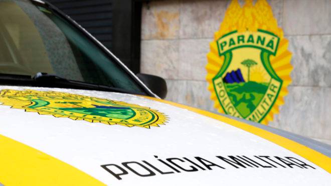 Emblema da Polícia Militar em uma viatura e na parede