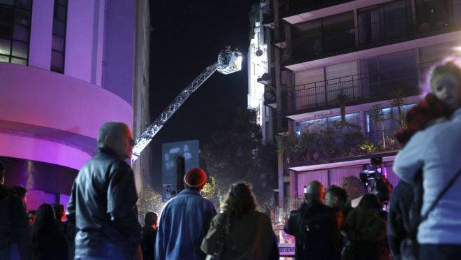 Bombeiros chilenos tentam entrar em um apartamento onde seis brasileiros morreram em Santiago, Chile