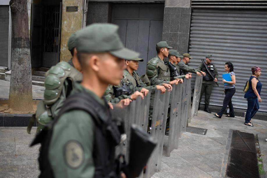 Membros da Guarda Nacional Bolivariana bloqueiam o acesso da imprensa ao Palácio Legislativo Federal, sede dos dois parlamentos da Venezuela, a Assembleia Nacional (oposicionista) e a Assembleia Nacional Constituinte (chavista), em Caracas, 28 de maio