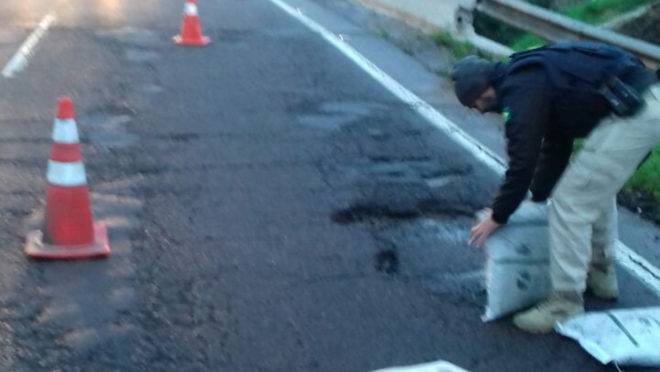 Policial rodoviário tapa buraco no Contorno Leste: nove veículos furaram pneu no local só na noite de domingo (2) para segunda (3).