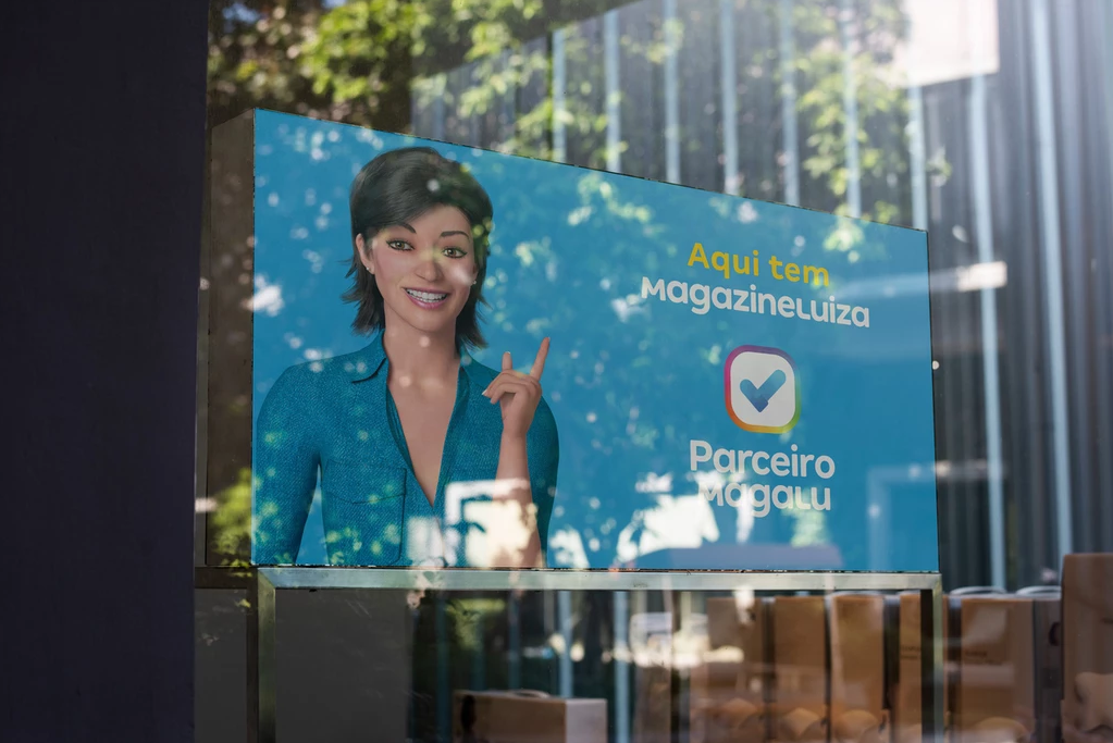Comunicação visual do aplicativo Parceiro Magalu instalado em fachada de loja, que traz a personagem Magalu e informa que a loja é parceira