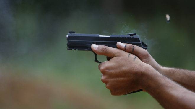 Pistola nas mãos de atirador.