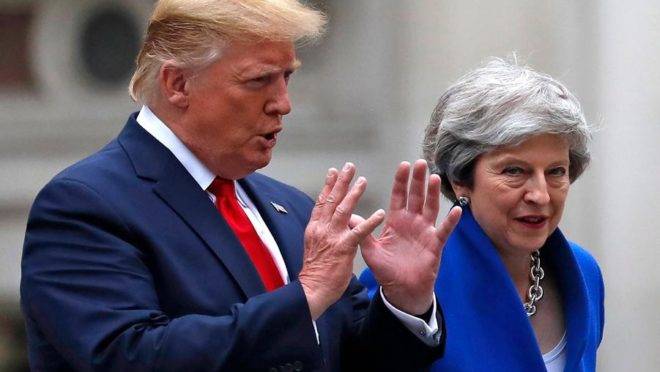 O presidente americano Donald Trump e a primeira-ministra britânica Theresa May caminham para uma entrevista coletiva em Londres, 4 de junho