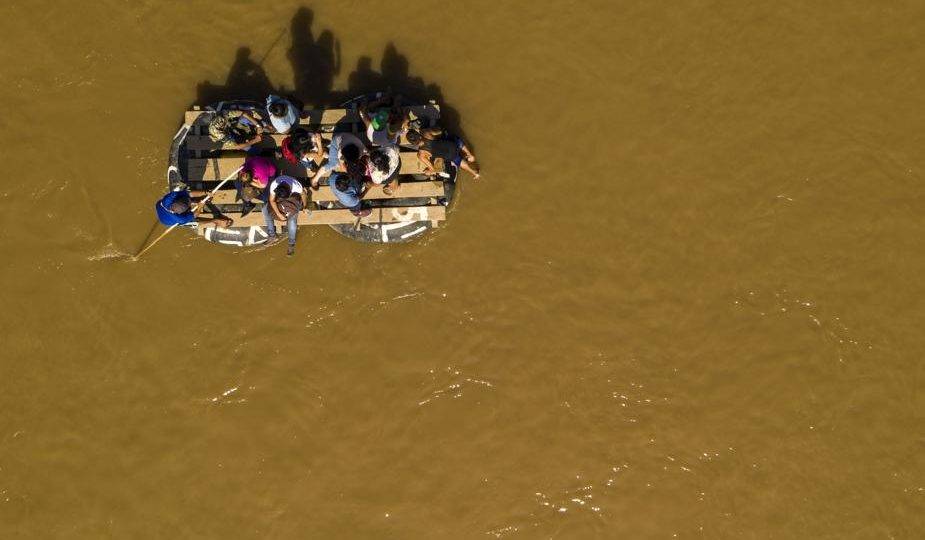 Migrantes usam um bote improvisado para atravessar o Rio Suchiate de Tecun Uman, na Guatemala, para Ciudad Hidalgo, no México, 6 de junho
